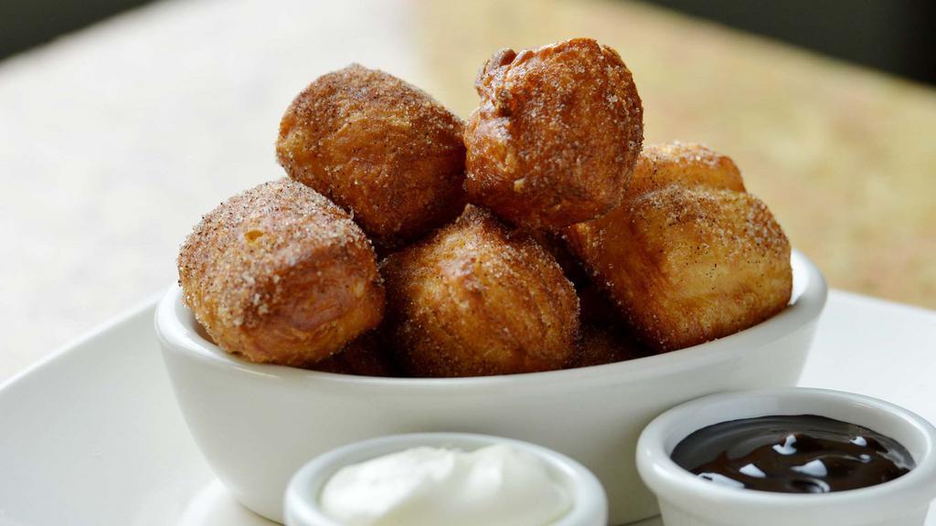 Cinnamon Sugar Beignets · Hot, fresh donuts covered in cinnamon sugar, served with chocolate and cream cheese dipping sauces