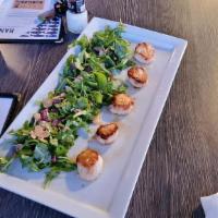 Scallops · Pan seared scallops surrounded by a blend of greens garnished with shaved red onion, walnuts...