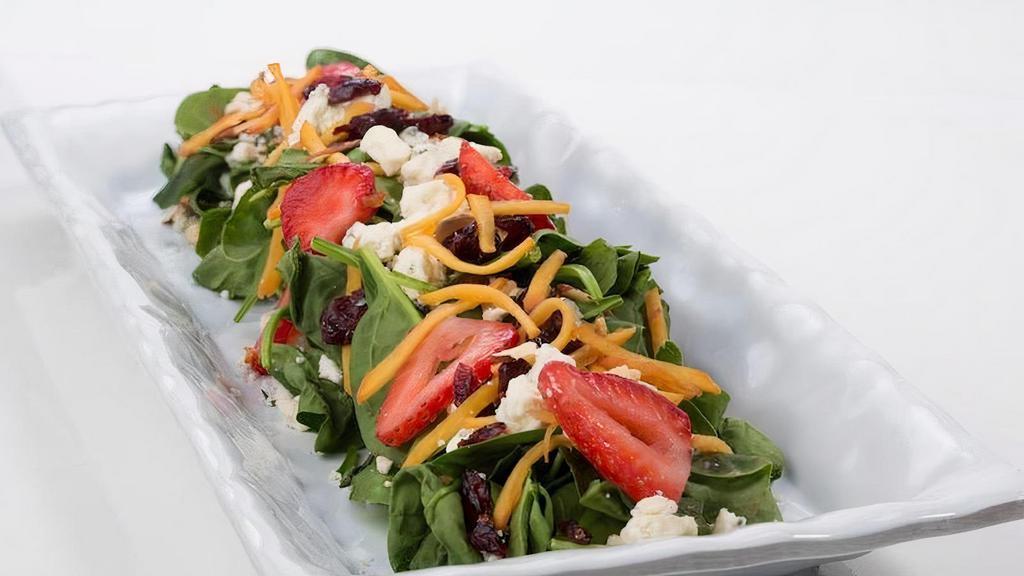 Spinach Salad ** · Spinach, Seasonal Fruit, Strawberries, Toasted Almonds, Blue Cheese Crumbles, Dried Cranberries.. Recommended Dressing: Raspberry Vinaigrette