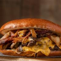 The Hustler · Pretzel Bun, Double 4 Oz Black Angus Meat, Melted Cheddar Cheese, Smoked Bacon and BBQ Sauce.