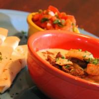 Caribe Dip · Bowl of cheese dip with grilled steak, chicken and shrimp, served with flour tortillas and p...