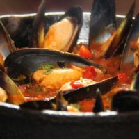 Mejillones · Sauteed mussels and spanish sausage cooked in tomato beer creole sauce, served with pressed ...