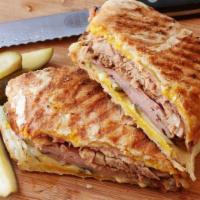 Cuban Sandwich · Roasted mojo pork, ham, Swiss cheese topped with pickles, mustard, drizzled with Tropicana s...