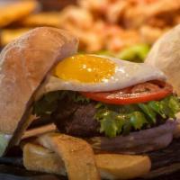 A Caballo Burger · Topped with sunny side up egg and aged cheddar cheese. Accompanied with potato chips, lettuc...