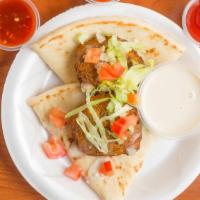 Falafel · Two fried ground chick peas with herbs served over pita with lettuce, tomato, onion, and tah...