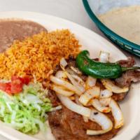 Bistec Encebollado · Steak with onions includes rice refried beans and tortillas. Incluye arroz frijoles y tortil...
