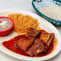 Costilla De Puerto Salsa Roja · Pork rib in red sauce with rice beans and tortillas. Arroz frijoles y tortilla.