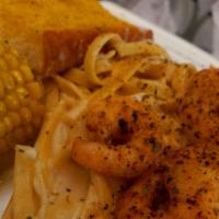 Shrimp Fetty · Fettuccine and fresh veggies tossed in a creamy Parmesan sauce topped with garlic jumbo shri...