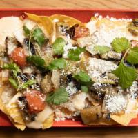 Macho Nachos · Crunchy corn tortillas, queso sauce, charred veggies, cotija and herbs +add your favorite sl...