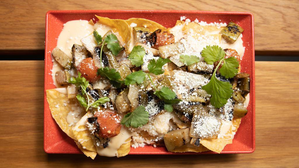 Macho Nachos · Crunchy corn tortillas, queso sauce, charred veggies, cotija and herbs +add your favorite slow cook meat +$5. 00.