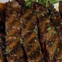 Metro Ribeye Steak · bone in ribeye steak pan seared to perfection, over rice.