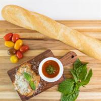 Garlic Bread · Homemade garlic confit butter spread on a toasted baguette slice topped with parmesan cheese...
