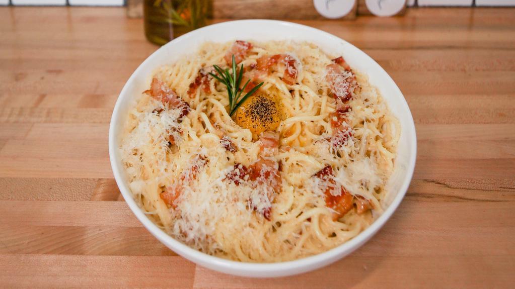 Spaghetti Carbonara · Spaghetti pasta with cheesy creamy sauce, bacon slices, and egg yolk.