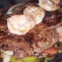 Fajita Ribeye Steak · A ribeye steak served on top of bell peppers, tomatoes and onions. Topped with four shrimps.