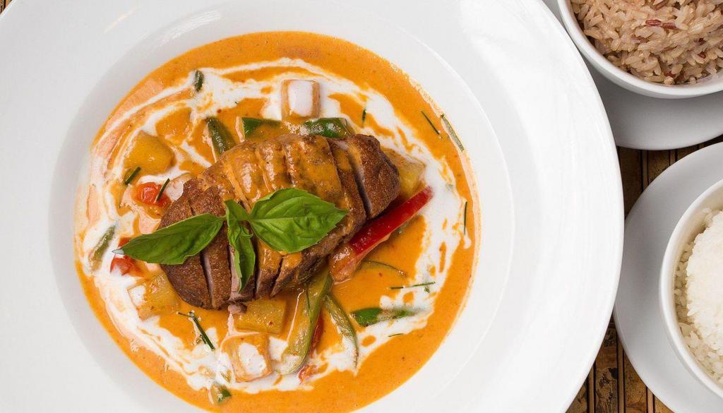 Roasted Duck Curry · Gluten-free. Roasted duck breast in chef's special red curry sauce with fresh pineapple, bell pepper, grape tomato, green bean, and Thai basil leaves.