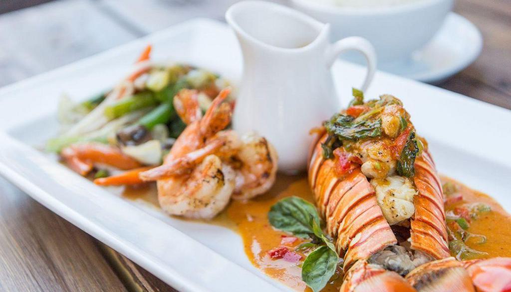 Lobster Panang · Gluten-free. Lobster tail and shrimps grilled in garlic butter sauce topped with panang curry and stir fried mixed vegetable.