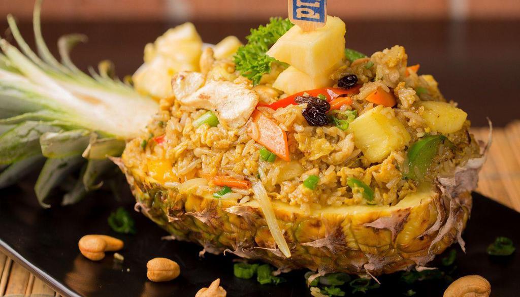 Pineapple Fried Rice · Jasmine rice stir fried with curry powder, egg, raisin, cashew nut, bell pepper, onion, carrot, and fresh pineapple. *Pineapple shell NOT included in take out order*