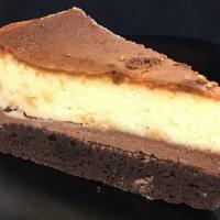 White Chocolate Brownie Cheesecake · White chocolate cheesecake slice with a hefty brownie base.