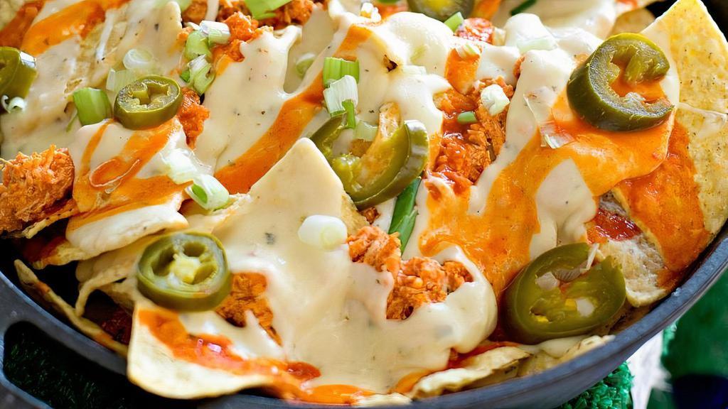 Loaded Buffalo Chicken Nachos · Nacho chips, ranch drizzle, buffalo sauce, blue cheese crumbles, scallions, jalapenos and chopped chicken