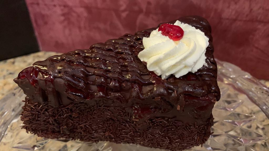 Raspberry Chocolate Cake Wedge · Chocolate chiffon cake layers filled with chocolate mousse, covered in raspberry chocolate ganache and topped with raspberry purée.