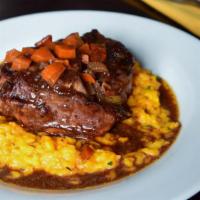 Osso Bucco Milanese · Veal shank cooked in vegetable ragu sauce with saffron risotto Milanese.