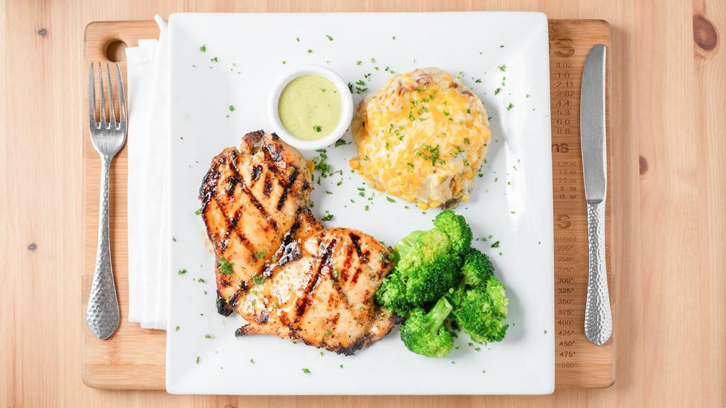 Pollo Con Cilantro Crema · Grilled chicken breast served with mashed potatoes, loaded with roasted corn and melted cheese, topped with our homemade cilantro crema and side of broccoli.