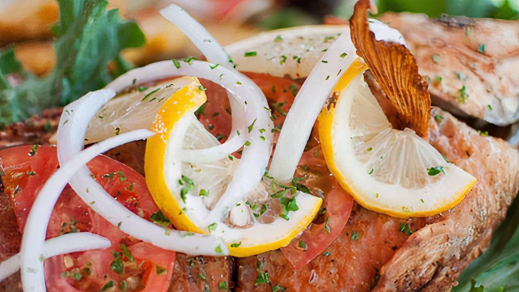 Pargo Rojo · Whole deep fried red snapper, served with white rice, green plantains, and salad.