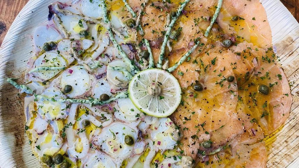 Salmon Carpaccio · Signature sauce, red onions, capers, black pepper, olive oil, lemon, and parsley.