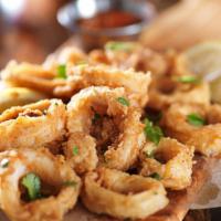 Crispy Calamari · Deliciously seasoned tender pieces of squid soaked in buttermilk, then coated in seasoned fl...