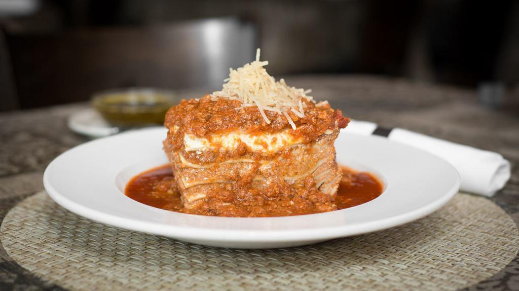 Lasagna Emiliana · Pasta layered with bechamel, meat sauce, ricotta, and Mozzarella topped with bolognese sauce.