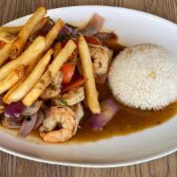 Shrimp Saltado · Wok seared shrimp, soy and oyster sauce, onion, tomato wedges, arroz con choclo, French fries