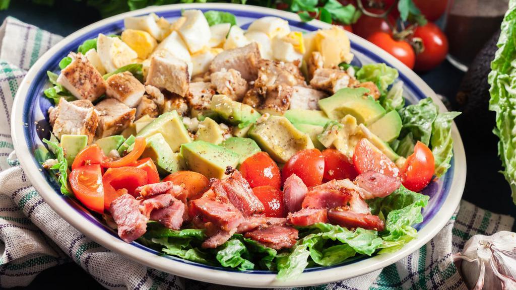 Cobb Salad · Turkey and ham, served on a bed of romaine lettuce with tomato, onion, egg, bacon, mixed cheeses, and croutons.