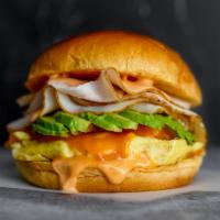 Brioche, Smoked Turkey, Egg & Avocado · 2 scrambled eggs, melted Cheddar cheese, smoked 
turkey, avocado, and Sriracha aioli in a wa...