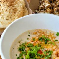 Hummus Bowl · a bowl of organic house made hummus served with a side of pickles, olives, and 2 sesame pita