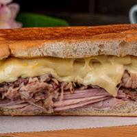 Cuban Sandwich · A Cuban classic served with ham, roasted pork, swiss cheese, pickles, and mustard. Served in...