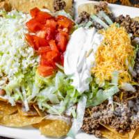 Crazy Nachos · A bed of chips topped with beans, beef and chicken, loaded with lettuce, sour cream, tomatoe...