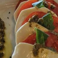 Caprese Salad · Sliced fresh mozzarella and tomatoes, seasoned with olive oil and Pesto sauce.