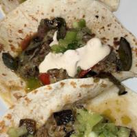 Beef Tenderloin Tacos · Toasted chilies, caramelized onions, manchego cheese, tomatillo salsa, chipotle cream.