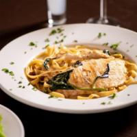 Creamy Tuscan Chicken · Sautéed chicken breast topped with spinach and sun dried tomatoes, served over fettuccine wi...