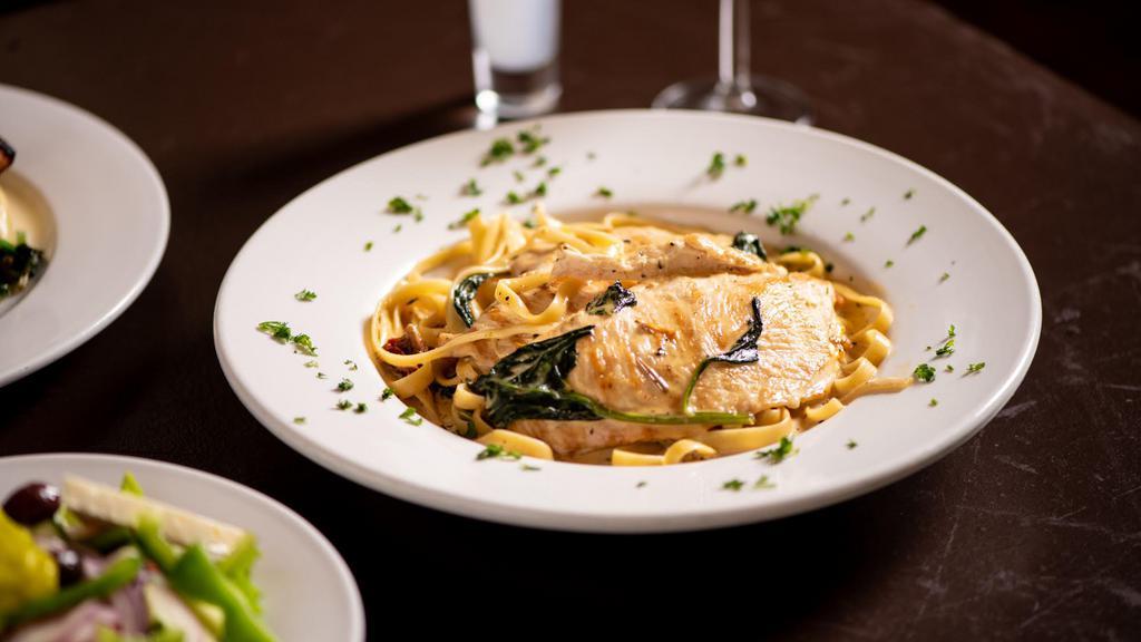 Creamy Tuscan Chicken · Sautéed chicken breast topped with spinach and sun dried tomatoes, served over fettuccine with cream sauce.