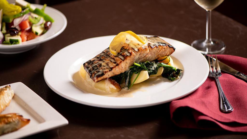 Salmon · Grilled salmon topped with lemon beurre blanc, served with sauteed spinach and lemon potatoes.