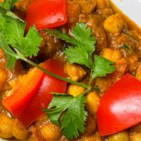 Chana Masala · (Vegan). Garbanzo beans cooked with spices, onion and bell pepper in a thick and rich sauce.