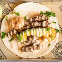 Surf & Turf Taco · Skirt steak and shrimp, topped with avocado and drizzled with sriracha ranch.