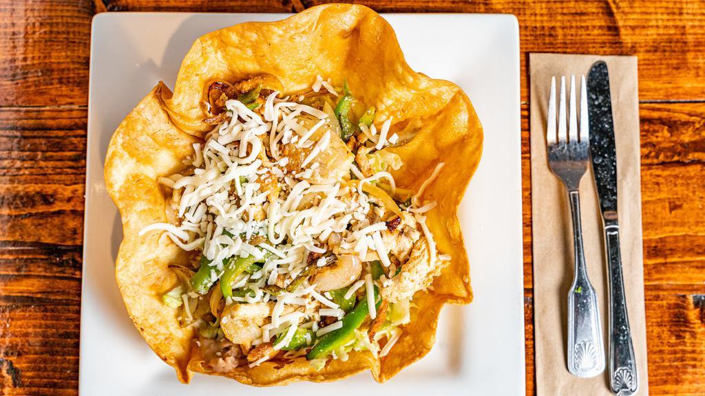 Fajita Taco Salad · Marinated grilled chicken with bell peppers and onions. Served with lettuce, and refried beans and topped with shredded cheese.