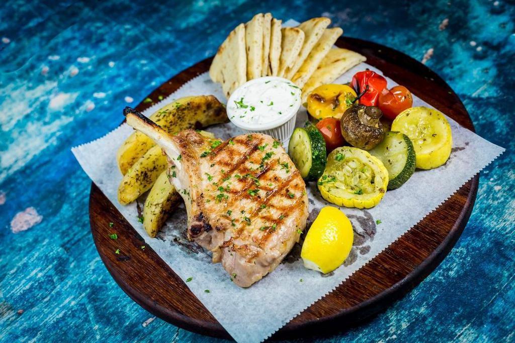 Pork Chop Steak · Marinated pork chop steak, served w/ lemon potatoes & grilled veggies, Tzatziki Sauce & Pita Bread