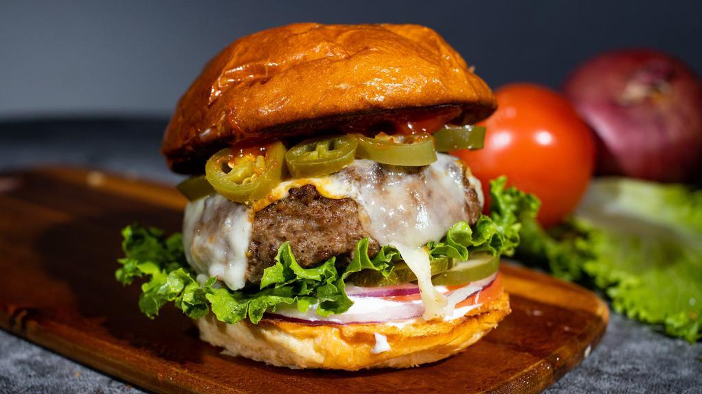 Glory Glory Jalapeño · American beef patty cooked medium topped with melted pepper jack cheese and spicy jalapeños. Served on a griddle brioche bun, butter lettuce, tomato, onion, and pickles.