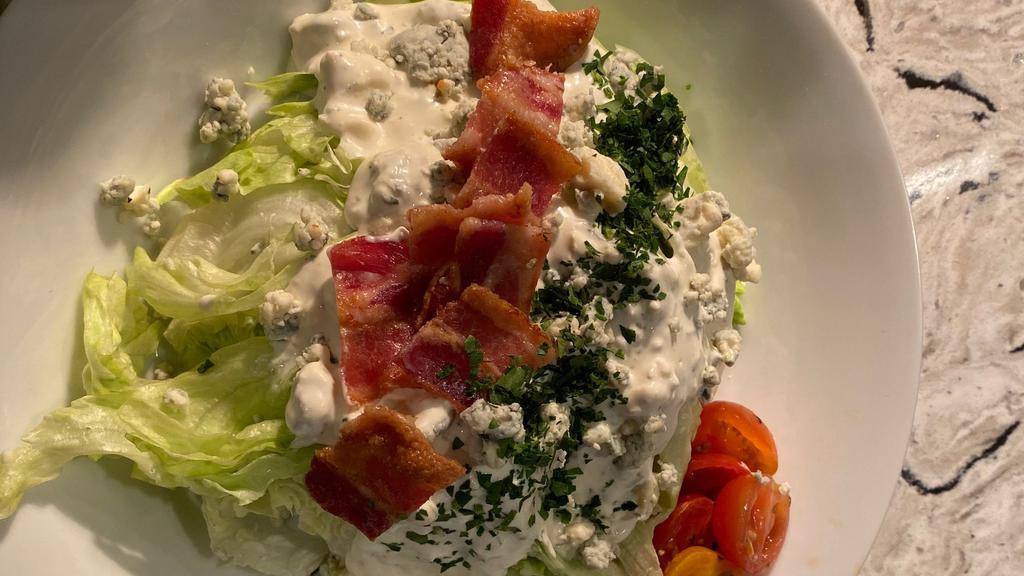 Wedge Salad · With crispy bacon, bleu cheese crumbles and house made bleu cheese dressing. May contain raw or undercooked ingredients. Consuming raw or undercooked ingredients may increase your risk of food-borne illness.