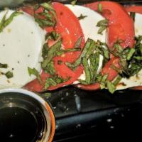 Caprese Salad · Basil, fresh mozzarella, and tomatoes topped with RS balsamic reduction.