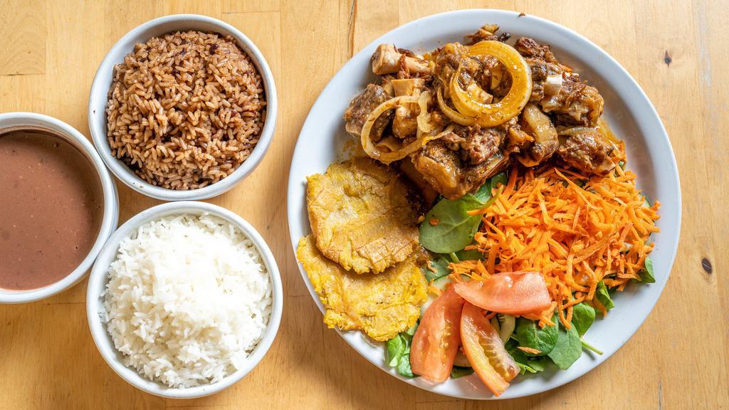 Oxtails · Stewed oxtails served with your choice of white rice or rice and red beans, salad and fried plantains.