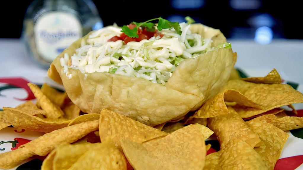 Taco Salad · A crispy flour tortilla shell filled with grill chicken or steak or ground beef or veggies topped with lettuce, tomatoes, sour cream and shredded cheese.
